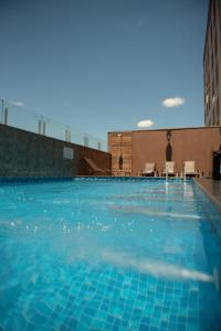 une grande piscine d'eau bleue dans l'établissement Bristol Infinity Rio Claro, à Rio Claro