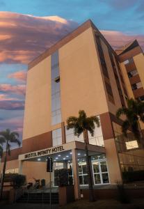 a building with palm trees in front of it at Bristol Infinity Rio Claro in Rio Claro