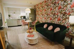 a living room with a green couch and a table at The Garden Room at Waddington Flats in Victoria