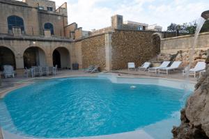 een zwembad met stoelen en een fontein bij OneFifty Holiday Home in Il-Pergla