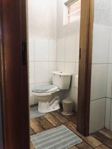 a bathroom with a white toilet in a room at Casa para temporada, represa Bortolan Poços de Caldas in Poços de Caldas