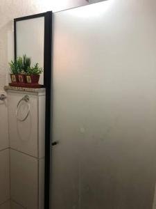a white refrigerator in a room with a mirror at Casa para temporada, represa Bortolan Poços de Caldas in Poços de Caldas