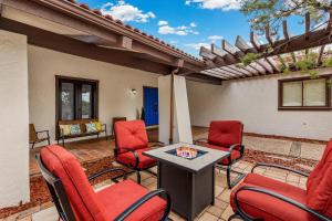 a patio with red chairs and a table at Large Spanish Villa -Hot tub- Pool -Gym- Game Room in Sedona