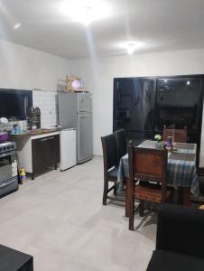 una cocina con mesa y sillas y una cocina con electrodomésticos en Alquiler Duplex Cosquin en Cosquín