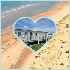 a heart shaped picture of a house on a beach at Private Caravan Camber Sands in Camber