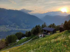 a house on a hill with the sunset in the background at Traditional chalet in the heart of nature in Sarreyer