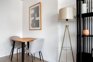 a dining room table with two chairs and a lamp at Tribeca Studio w Tons of light Gym Pool NYC-118 in New York