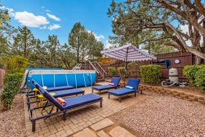 a patio with two chairs and an umbrella at Large Spanish Villa -Hot tub- Pool -Gym- Game Room in Sedona