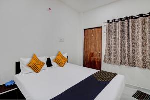1 dormitorio con 1 cama con almohadas de color naranja y negro en SPOT ON Hotel Tulsi Stay Inn, en Nagpur