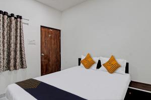 a bedroom with a bed with orange and black pillows at SPOT ON Hotel Tulsi Stay Inn in Nagpur