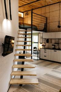 loft apartments OLD MILL في Sarny: درج خشبي في غرفة مع مطبخ