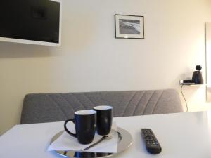 a table with two coffee mugs and a remote control at Immalanjärvi in Imatra