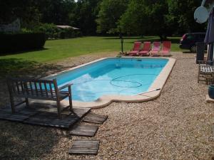 uma piscina com um banco e duas cadeiras em Rowland's French Retreat em La Rochebeaucourt-et-Argentine