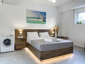 a bedroom with a bed and a washing machine at Sunset Seaside Apartments & Studios in Rethymno +35 photos