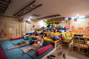 a group of people laying on pillows in a room at Gypsy Nest Hostel in Agra