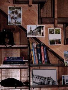 un estante de libros con libros y fotos. en Hostería Miller FRENTE AL MAR, en Bahía Mansa