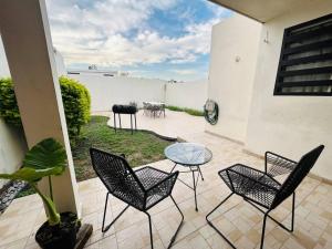 un patio con sillas y una mesa de cristal. en Great house in Monterrey 3 bedroom wifi AC parking, en Monterrey