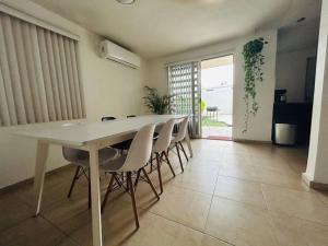 comedor con mesa blanca y sillas en Great house in Monterrey 3 bedroom wifi AC parking, en Monterrey