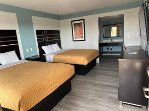 um quarto de hotel com duas camas e um lavatório em Siesta Inn em Fresno