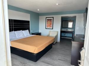 una camera d'albergo con letto e scrivania di Siesta Inn a Fresno