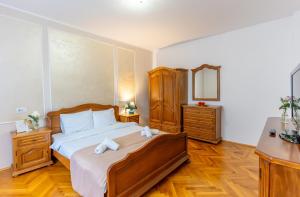 a bedroom with a bed and a dresser and a mirror at Vila Crișan in Braşov