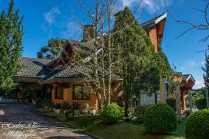 una casa con un albero davanti di Villa da Esperança a Campos do Jordão