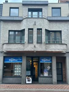 a large brick building with windows and a storefront at The 40 work or holiday new Appt in Comines