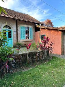 una casa con una puerta azul y algunas plantas en Vila Luiza Ubatuba, en Ubatuba