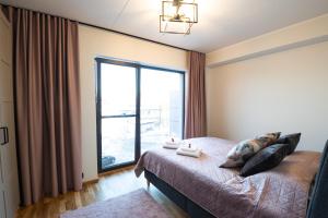 Schlafzimmer mit einem Bett und einem großen Fenster in der Unterkunft R64 Premium Apartments in Tartu