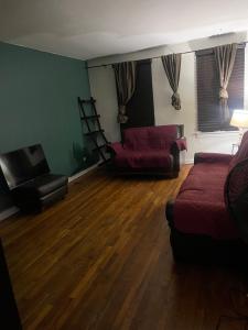 sala de estar con sofá y silla en Comfy apartment en Hollis