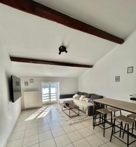ein Wohnzimmer mit einem Sofa und einem Tisch in der Unterkunft Spacieux & Charmant 2 chambres - Lyon Bron Eurexpo in Bron