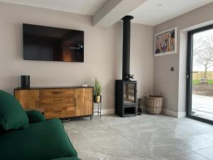 uma sala de estar com lareira e uma televisão na parede em Brian’s Escape em Great Driffield