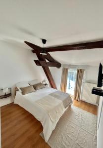 1 dormitorio con 1 cama grande y techo de madera en Spacieux & Charmant 2 chambres - Lyon Bron Eurexpo, en Bron