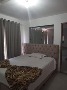 - une chambre avec un grand lit et une couverture zébrée dans l'établissement R&L Pousada, à Cabo Frio