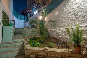 un patio con plantas y escaleras en un edificio en Kassi Hanni Guesthouse en Tesalónica