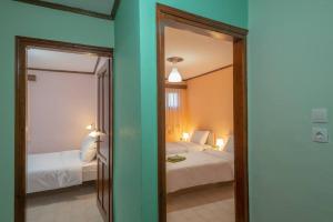 a bedroom with two beds and a mirror in a room at Kassi Hanni Guesthouse in Thessaloniki