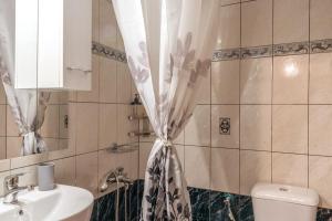 a bathroom with a sink and a shower curtain at Kassi Hanni Guesthouse in Thessaloniki