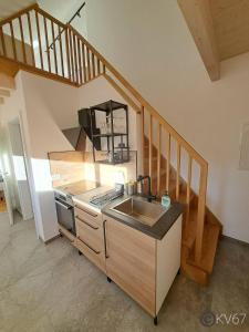 eine Küche mit einem Waschbecken und einer Treppe in der Unterkunft Jogilation in Sankt Jakob im Walde