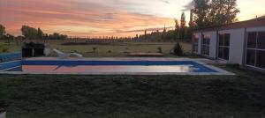 Casa Quinta San Miguel con Piscina, Pool, Metegol y Ping Pong في Salto de las Rosas: مسبح في ساحة منزل مع غروب الشمس