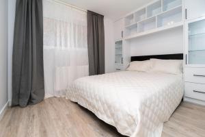 a white bedroom with a bed and a window at My cozy home in Toronto in Toronto