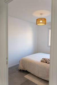a white bedroom with a bed and a chandelier at Zen et Romantique Room - Harmonie in Moulins