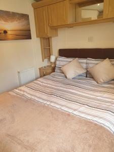 a bedroom with a large bed with two pillows at Sunrise Holidays Skegness - Diamond in Skegness