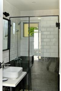 a bathroom with a sink and a glass shower at Honky Tonk Punta Cana in Punta Cana