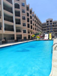 una gran piscina frente a un edificio en Solo beach front studio or for couple, en Hurghada