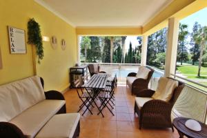 a screened in porch with chairs and a fireplace at Da Praia Apartment - Pool & Tenis in Vilamoura