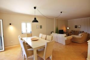 a dining room and living room with a table and chairs at Da Praia Apartment - Pool & Tenis in Vilamoura