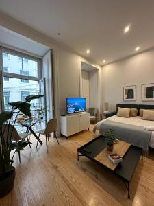 Apartamento no centro de Lisboa في لشبونة: غرفة معيشة كبيرة مع سرير وتلفزيون