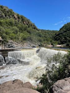 een waterval in het midden van een rivier bij Cabaña La ventana de la luna in Cuesta Blanca