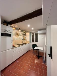 a kitchen with white cabinets and a red tile floor at La trilogie de Pagnol by K6 in Aubagne