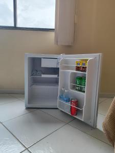 a small refrigerator with its door open in a kitchen at Suíte Funcional Independente - Via Park Flat Service - Campos dos Goytacazes in Campos dos Goytacazes